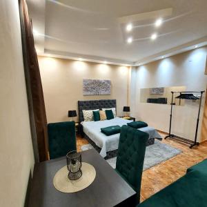 Senjak (historical)Emerald Apartment Belgrade的卧室配有一张床和一张桌子及椅子