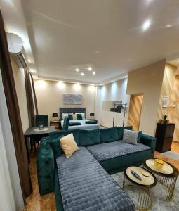 Senjak (historical)Emerald Apartment Belgrade的客厅配有绿色沙发和桌子