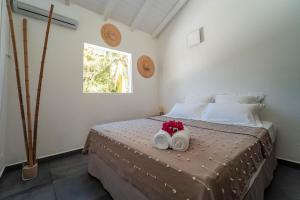 圣安尼La Petite Caravelle Guadeloupe的一间卧室配有带2条毛巾的床和窗户。