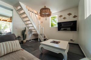 圣安尼La Petite Caravelle Guadeloupe的带沙发和电视的客厅以及楼梯。