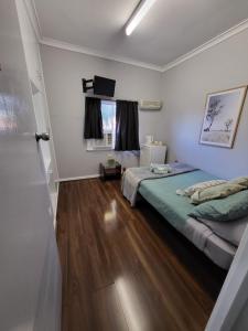 Everlasting Guesthouse Morowa的一间卧室配有两张床和电视。