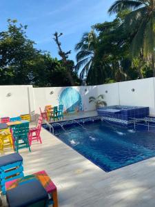 圣维罗尼卡HOTEL ARRECIFE的围栏旁的游泳池,配有五颜六色的桌椅