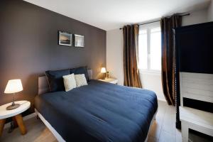 乌瑞基尼Appart 12 pers 5km plage Hendaye的一间卧室设有蓝色的床和窗户。