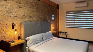 瓜达拉哈拉Casa Corazon的一间卧室设有一张床和砖墙
