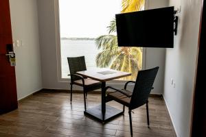 卡塔赫纳Hotel Caribbean Cartagena的窗户客房内的桌椅