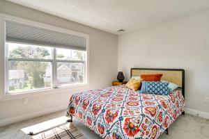 朗布兰奇Sleek Long Branch Vacation Rental with Yard and Patio!的一间卧室设有一张床和一个大窗户