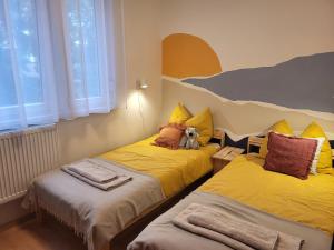 塞克希费黑瓦尔Koala Apartman Székesfehérvar的两张床位于一间房间,中间有泰迪熊