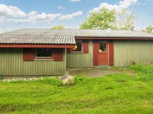 Remmer StrandThree-Bedroom Holiday home in Struer 1的一座有红色门和院子的房子