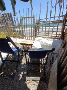 曼克拉Mancora Apartments的围栏前的两把椅子和一张桌子
