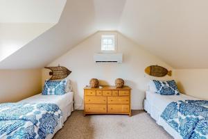楠塔基特About Time的阁楼卧室设有两张单人床和窗户。