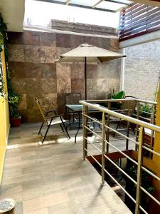 墨西哥城Hidden house的庭院配有桌椅和遮阳伞。