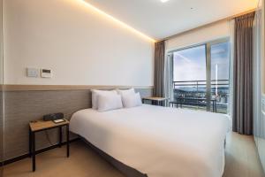 仁川市Skytop Hotel Incheon Airport的一间设有大床和窗户的酒店客房