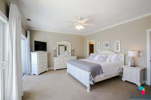 泰比岛Beachfront Oasis At Tybee Island的一间白色卧室,配有床和电视