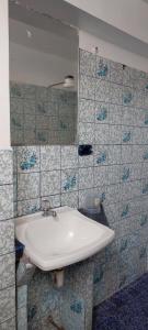 利马Hostal Reyna的浴室设有白色水槽和蓝色瓷砖