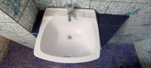 利马Hostal Reyna的浴室铺有蓝色和白色瓷砖,配有白色水槽。