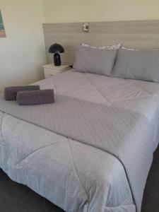 梅林布拉Norfolk Pines Motel的一张配有白色床单和枕头的大床