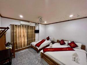 琅勃拉邦Luang Prabang Rosie Place的酒店客房设有两张床和窗户。