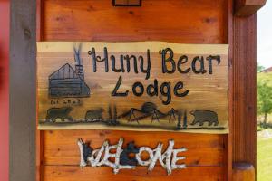 鸽子谷Huny Bear Lodge的木墙上的标志,上面写着 ⁇ 指熊小屋