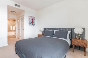 洛杉矶Brand New Luxury Apartment WeHo的一间卧室配有一张大床和灰色的床罩