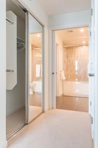 洛杉矶Brand New Luxury Apartment WeHo的玻璃门通向带浴缸的浴室