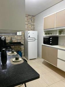 彼得罗利纳Linda Casa com piscina e totalmente climatizada Airbn b的带冰箱和桌子的厨房