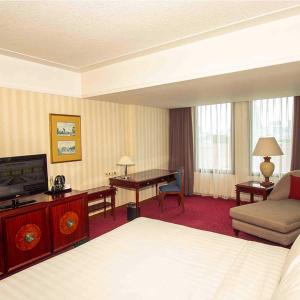 雅加达红顶会议中心酒店 的酒店客房配有一张床、一张书桌和一台电视。