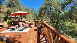 奥克赫斯特Yosemite Mountain Retreat的一个带椅子和遮阳伞的木制甲板