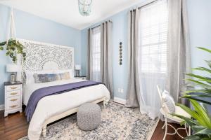 查尔斯顿Stunning Secret Courtyard - 1 BLOCK TO KING的一间拥有蓝色墙壁的卧室,配有一张床和地毯