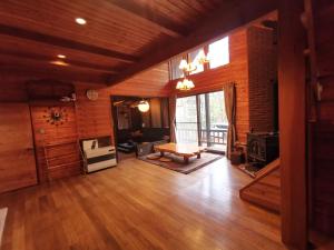 嬬恋村木香苑的大型客厅铺有木地板,设有大窗户