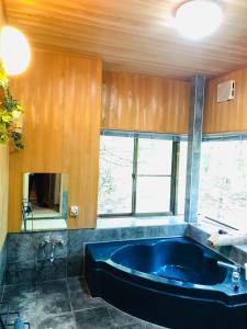 嬬恋村木香苑的一间位于客房内的带大型蓝色浴缸的浴室