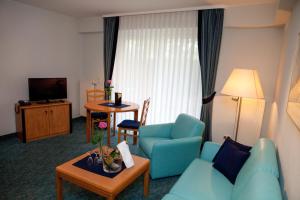 NeuhofLandhotel Imhof的客厅配有蓝色的沙发和桌子