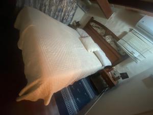 圣贝纳迪诺Country village San Bernardino的一张带白色枕头的床和一本书