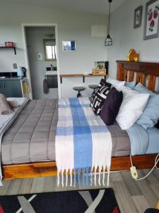 玛塔玛塔Denchys B&B的一间卧室配有一张大床,床上有毯子