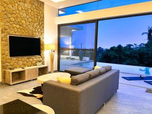 苏梅岛VILLA CLARISSE - SEAVIEW - 4 Bedrooms的带沙发和电视的客厅