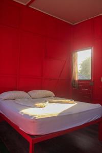 别霍港摇摆J之家旅舍的红色的卧室,配有一张红色墙壁的床