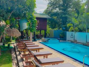 蒂瑟默哈拉默Yala River Front Hotel & Restaurant的一个带躺椅的游泳池以及度假村