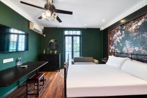 上海門堂酒店（浦東機場店）的卧室配有白色的床和绿色的墙壁
