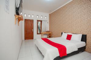 贝克西RedDoorz Syariah near Jatisampurna Hospital的一间卧室配有一张床铺,床上铺有红色毯子