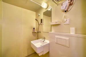 上海門堂酒店（浦東機場店）的白色的浴室设有水槽和镜子