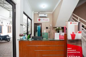 贝克西RedDoorz Syariah near Jatisampurna Hospital的一座带摩托车的大楼内的前台