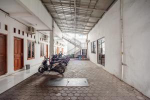贝克西RedDoorz Syariah near Jatisampurna Hospital的停在建筑物走廊上的一排摩托车