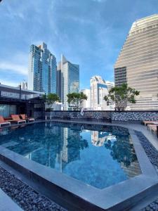 曼谷Ramada by Wyndham Bangkok Sukhumvit 11的一座城市天际线的游泳池