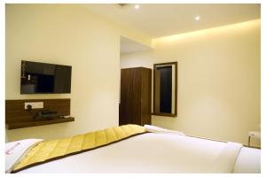 拉马纳塔普拉姆Starwin Residency的一间卧室配有一张床和一台平面电视