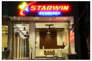 拉马纳塔普拉姆Starwin Residency的一间星光餐厅,前面有标志