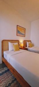外南梦Betah Homestay Banyuwangi的一间带两张床和一张沙发的卧室