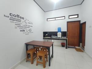 DondoHome Syariah Guest House Ampana的办公室配有桌子、两把椅子和一张书桌