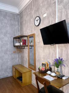 顺化Amy Hostel Hue的客厅配有桌子和平面电视。