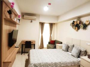 三宝垄Warhol Residence at Louise Kienne Simpang Lima Semarang的一间卧室配有一张床、一张书桌和一台电视