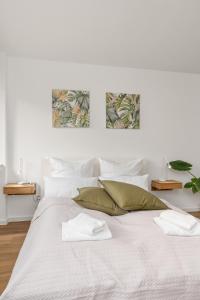 不莱梅Studio-Apartment im Stadtzentrum的白色卧室配有带绿色枕头的大型白色床