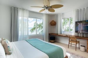 康隆尼角海角精品酒店的一间卧室配有一张床、一张桌子和风扇